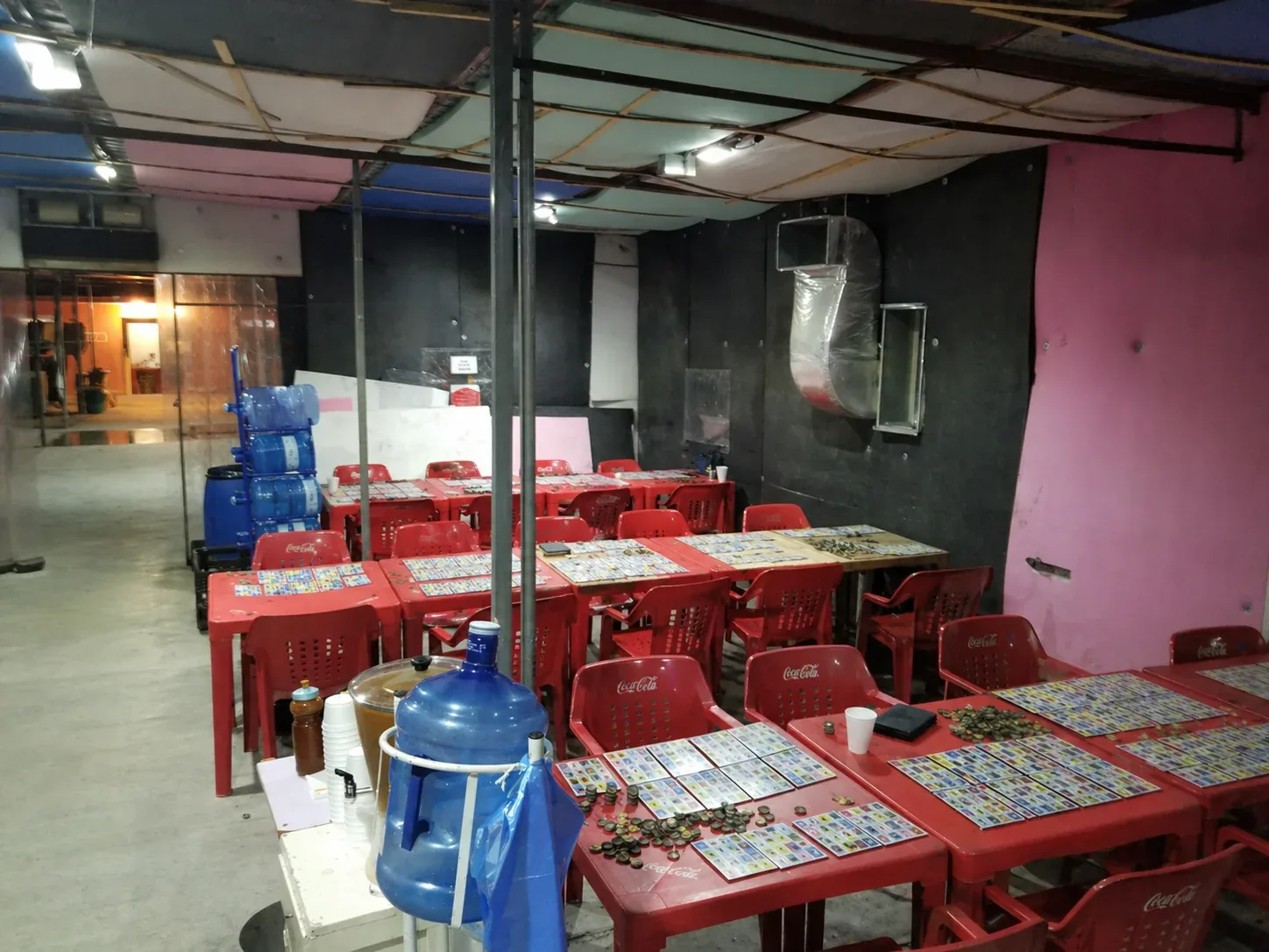 Interior de Lotería Lulú con mesas y sillas rojas listas para jugar